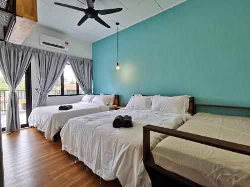 two beds in a bedroom with a ceiling fan at Port Dickson Pool Villa - Ruma66 (Up to 22 Pax) in Port Dickson