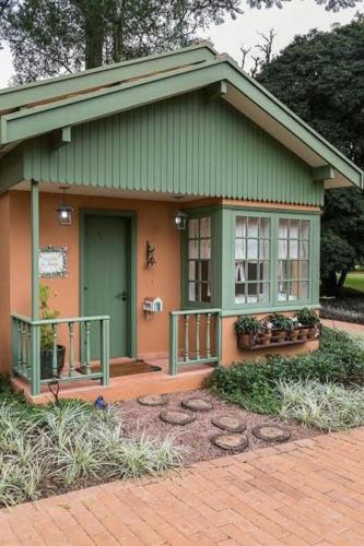 ein kleines Haus mit grüner Tür und Fenstern in der Unterkunft Guest House BSP 