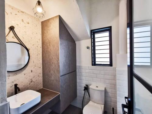 a bathroom with a toilet and a sink and a mirror at Port Dickson Pool Villa - Ruma66 (Up to 22 Pax) in Port Dickson