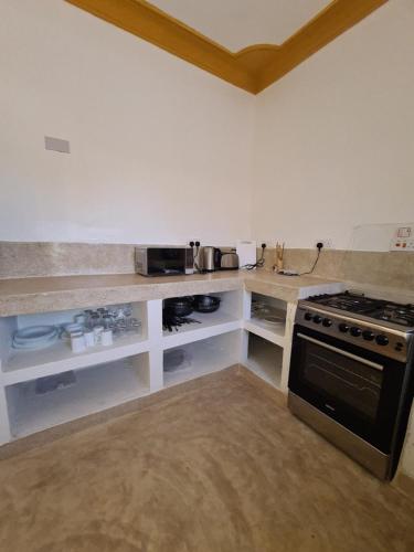 a kitchen with a stove and a counter top at Linda's Little Lincoln in Watamu