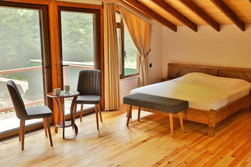 a bedroom with a bed and two chairs and a table at Lal Hayal Konakları in Sakarya