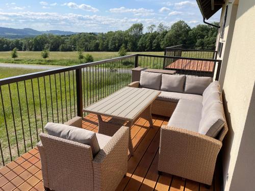 a balcony with couches and a table and chairs at HP APARTMÁNY SKIAREÁL- Buková Hora v Orlických horách 100 m od lanovky in Červená Voda