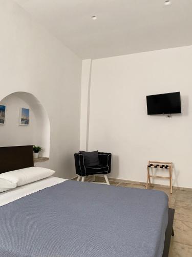 a bedroom with a bed and a tv on the wall at Al Duomo Rooms in Corato