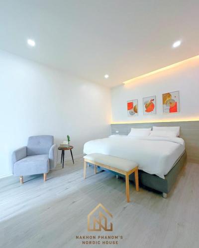 1 dormitorio con 1 cama grande y 1 silla en นครพนม นอร์ดิกเฮ้าส์ en Nakhon Phanom