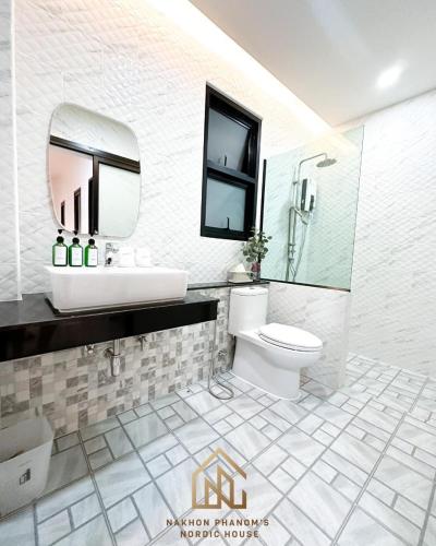 ein Badezimmer mit einem Waschbecken, einem WC und einem Spiegel in der Unterkunft นครพนม นอร์ดิกเฮ้าส์ in Nakhon Phanom
