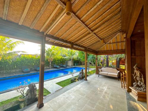 an open pavilion with a pool in a house at Nunu Bali Eco Friendly Retreat in Canggu