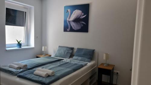 a bed with two pillows on it in a bedroom at Swan Apartman - Keszthely in Keszthely