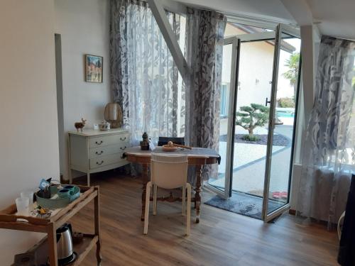 a room with a table and a glass door at Un petit coin de paradis à Haute Jarrie in Jarrie