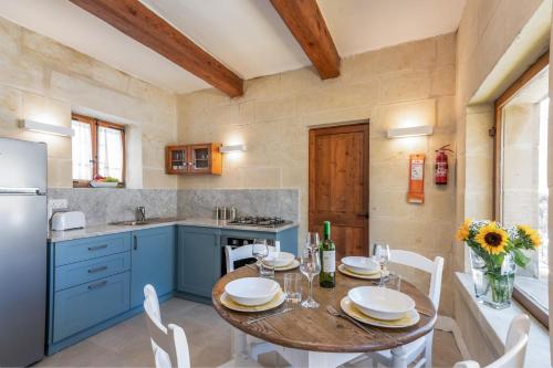 a kitchen with a table and chairs and a refrigerator at Dar ta' Mansi Farmhouse with Private Pool in Għarb