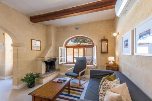 a living room with a blue couch and a fireplace at Dar ta' Mansi Farmhouse with Private Pool in Għarb