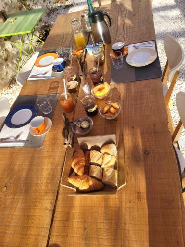 drewniany stół z kupą jedzenia w obiekcie Bastide de la madeleine w mieście Pougnadoresse