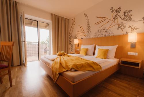 a hotel room with a bed and a large window at Landhotel Schwabenhof in Heiligenbrunn