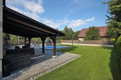 a pavilion with a pool in a yard at Apartmán Jizerské hory in Hejnice