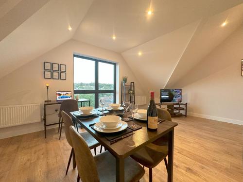 a dining room with a table with a bottle of wine at Chic and Airy Apartment in Royal Tunbridge Wells