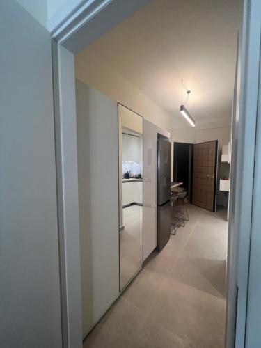 a room with a hallway with a refrigerator and a kitchen at KK Athens Fine Stay-Steps to Metro-Modern & Cozy Apartments in Athens