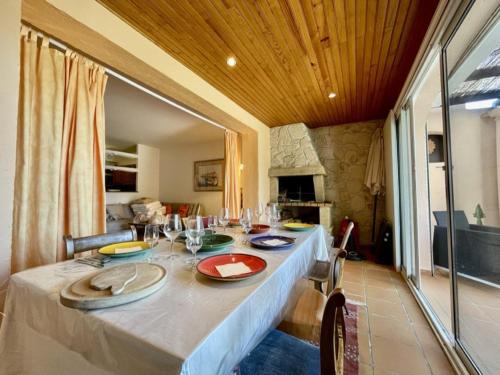 une salle à manger avec une table et une cheminée en pierre dans l'établissement Villa à Cavalaire-sur-Mer avec piscine, sauna, parking et animaux acceptés - FR-1-226B-156, à Cavalaire-sur-Mer