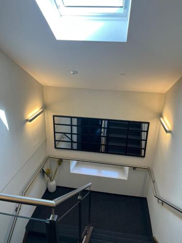 a room with stairs and a skylight in a building at Hotel de ville d'Yvonand in Yvonand