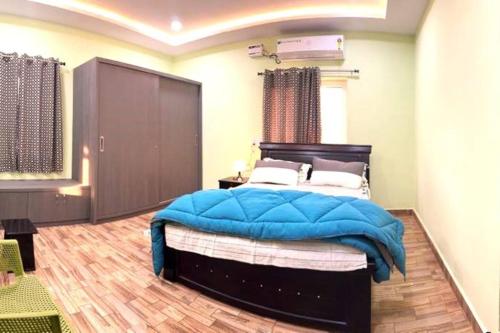 a bedroom with a large bed with a blue blanket at Willow the Villa in Hyderabad