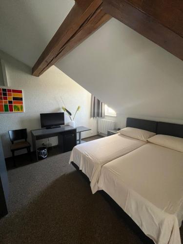 a bedroom with a large white bed and a desk at Hotel de ville d'Yvonand in Yvonand