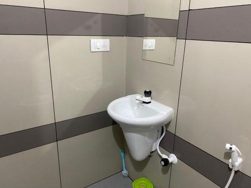 a bathroom with a white sink and a mirror at HOLLYWOOD Rooms in Sultan Bathery