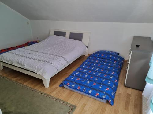 a small bedroom with a bed with a blue cover at House Osjek Ilidza in Ilidza