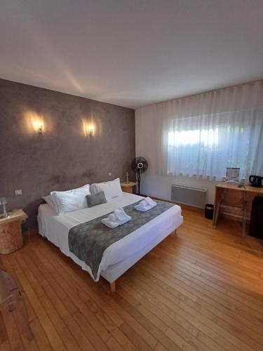 1 dormitorio con 1 cama blanca grande en una habitación en Le Clos du Bois Joli, en Lagnieu