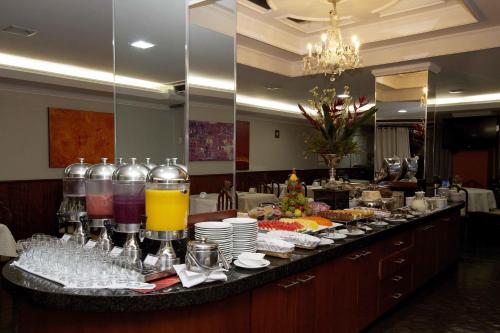 a buffet line with food and drinks on a table at Bristol Exceler Campo Grande in Campo Grande
