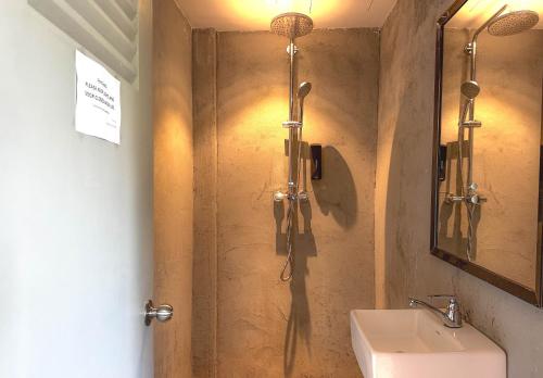 a bathroom with a shower and a sink at Arch Dormitorio Cenang in Pantai Cenang