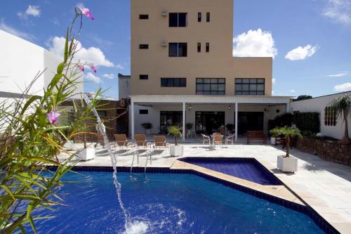 a house with a swimming pool in front of a building at Bristol Exceler Campo Grande in Campo Grande