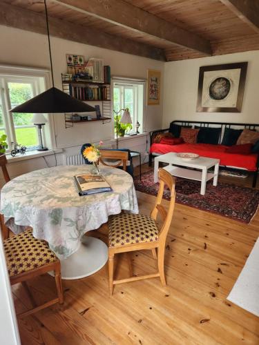 een woonkamer met een tafel en stoelen en een bank bij Norrekås Beach Studios in Borrby