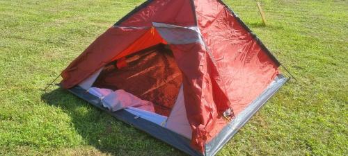 una tenda rossa e rossa, seduta sull'erba di A&G SODYBA CAMP žvejų kampelis a Plungė