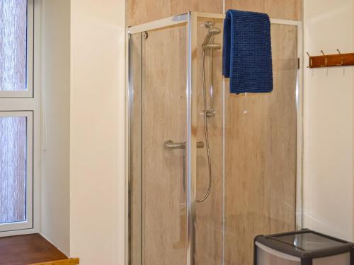 um chuveiro na casa de banho com uma toalha azul em Harbour Apartment em Nairn