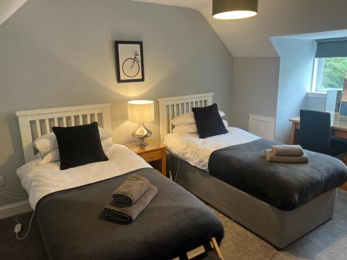 a bedroom with two beds with towels on them at The Old Post House in Kyle of Lochalsh