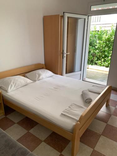 Cette chambre comprend un grand lit et une fenêtre. dans l'établissement Anita Guest House, à Tivat