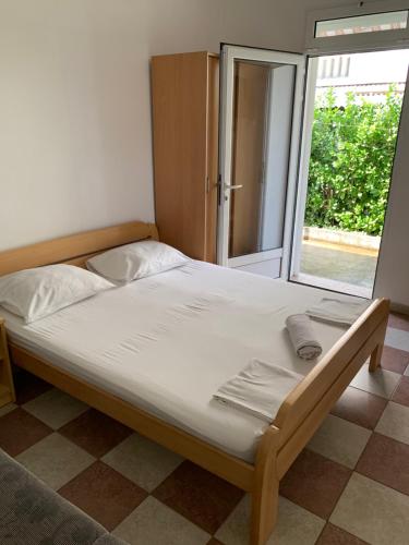 Cette chambre comprend un grand lit et une fenêtre. dans l'établissement Anita Guest House, à Tivat