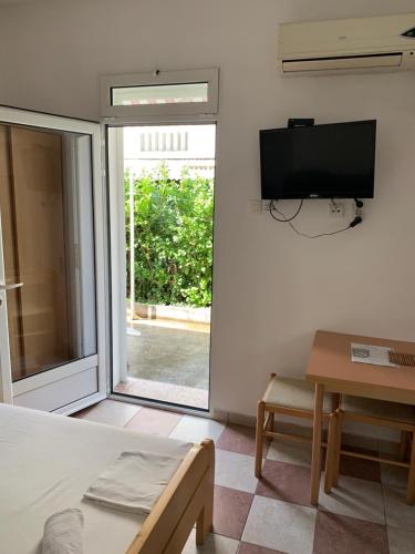 a room with a bed and a tv on the wall at Anita Guest House in Tivat
