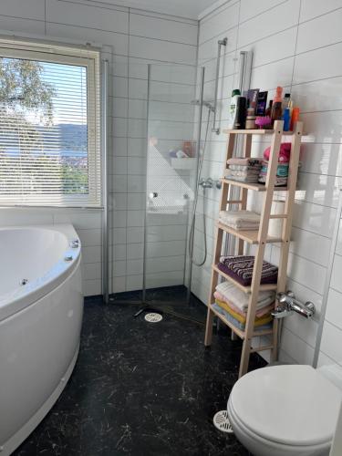 een badkamer met een bad, een toilet en een plank bij Holiday home with seaview in Flekkefjord in Flekkefjord