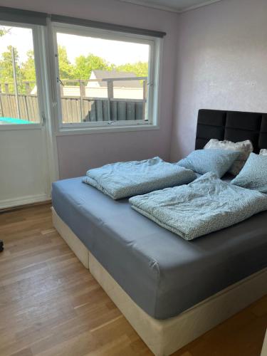 1 dormitorio con cama con sábanas azules y ventana en Holiday home with seaview in Flekkefjord en Flekkefjord