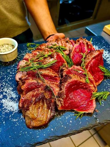 a piece of meat on a blue cutting board at Hotel de ville d'Yvonand in Yvonand
