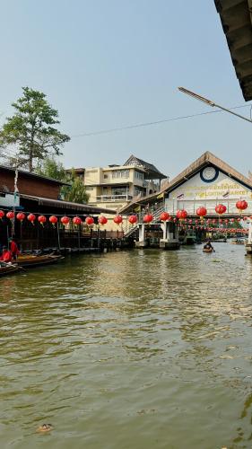 un río con un grupo de edificios y sombrillas en LOYD Ratchaburi, en Ban Tha Nat (4)