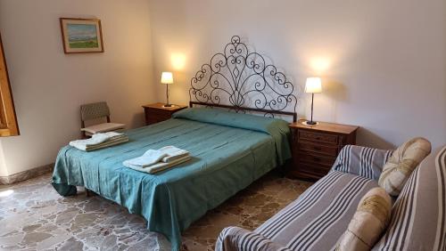 Magic Etna and glamorous blue sea في ريبوستو: غرفة نوم بسرير وكرسي عليها مناشف