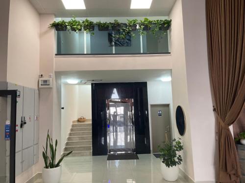 a lobby with stairs and a door with plants at Mizirawi Historic Hotel in Ramallah