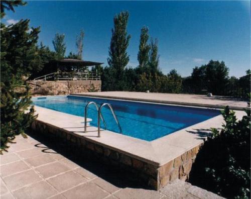 a large swimming pool in a yard with at Cueva romántica - Jacuzzi in La Cabrera