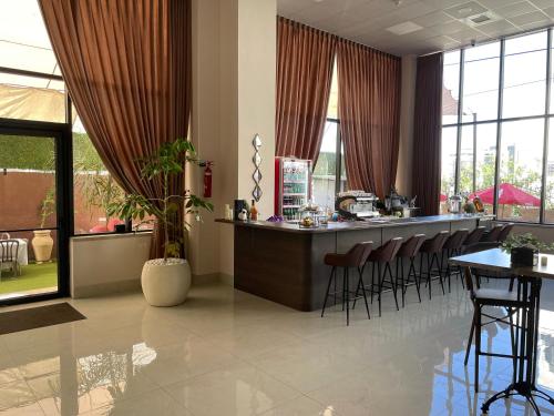 a bar with stools in a room with windows at Mizirawi Historic Hotel in Ramallah