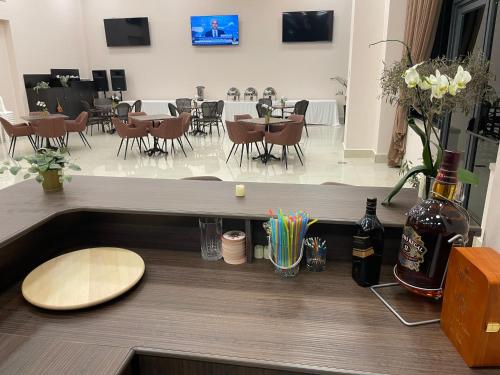 a counter with a bottle of wine and some tables and chairs at Mizirawi Historic Hotel in Ramallah