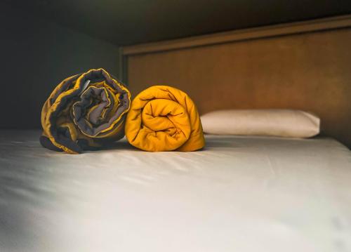 two yellow pillows are sitting on a bed at Arch Dormitorio Cenang in Pantai Cenang