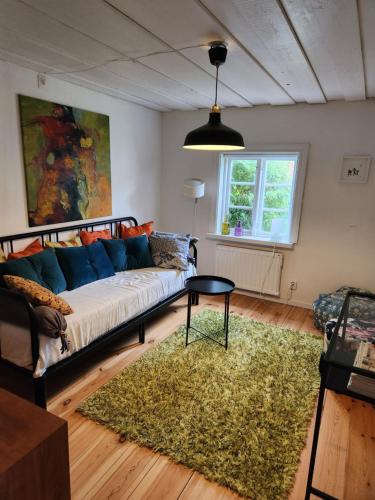 een woonkamer met een bank en een tapijt bij Norrekås Beach Studios in Borrby