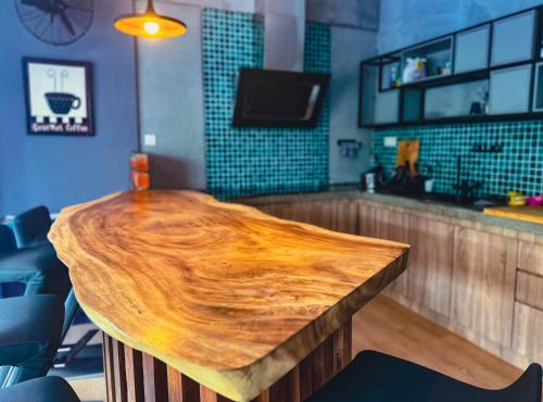 a wooden table in a restaurant with a bar at Arch Dormitorio Cenang in Pantai Cenang