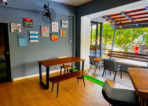 a dining room with tables and chairs and a piano at Arch Dormitorio Cenang in Pantai Cenang