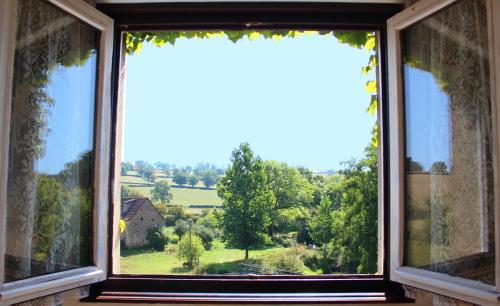 a window with a view of a green field at Le moulin de vaux in Nochizé